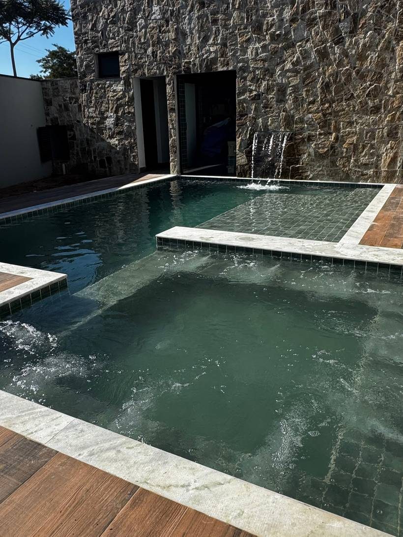 Piscina com cascata em muro de pedra